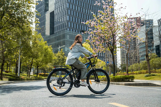 DUOTTS electric commuter bike being ridden by woman on sunlit city street with modern skyscraper backdrop